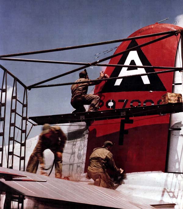 Ground crew paint new markings on B-17 Flying Fortress.